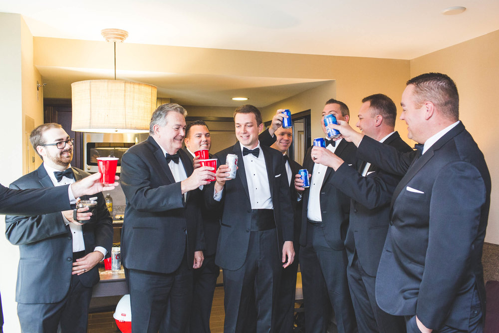 grooms party toasting to the upcoming wedding day in a hotel room