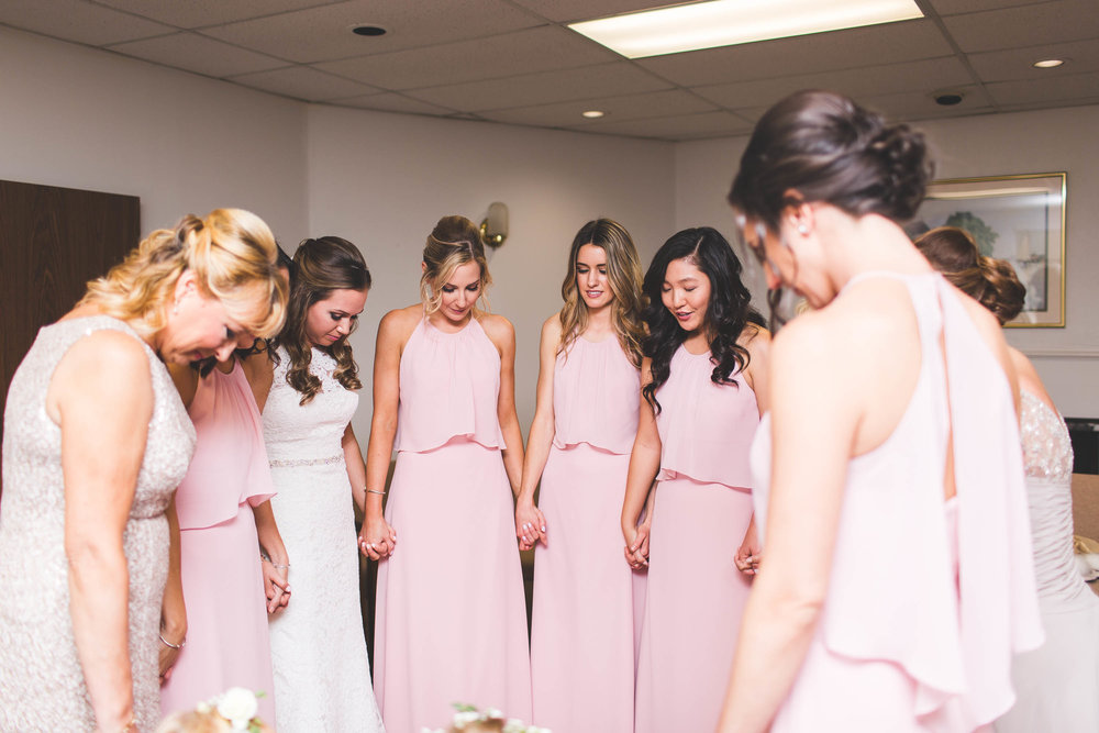 bridal party praying for bride on her wedding day