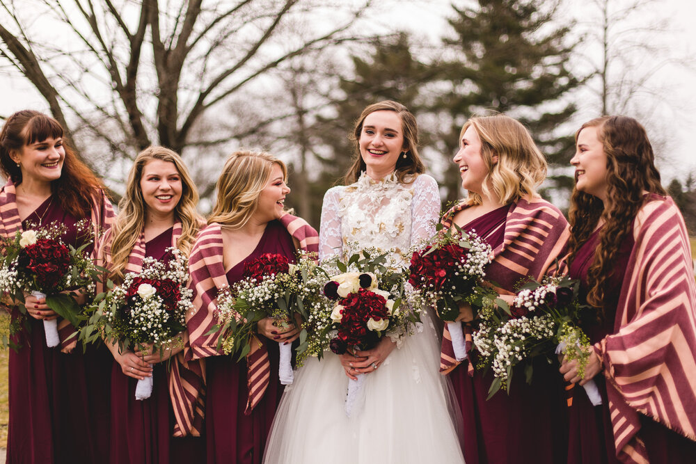 bride and bridesmaids laughing during a winter wedding at boardman park in youngstown ohio wedding photographer