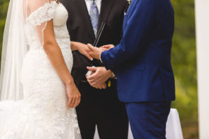 groom puts ring on bride during ohio wedding ceremony