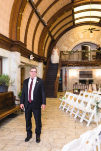 Father waits for bride as she comes down stairs in ornate historic train station room in columbus ohio