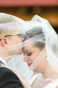 groom kisses bride's forehead under wedding veil in columbus ohio