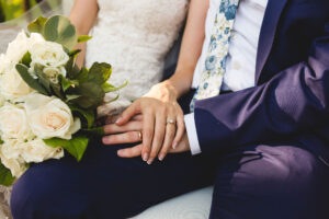 Bride and groom holding hands with rings on their wedding day