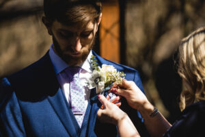 Mom pins flowers onto the groom