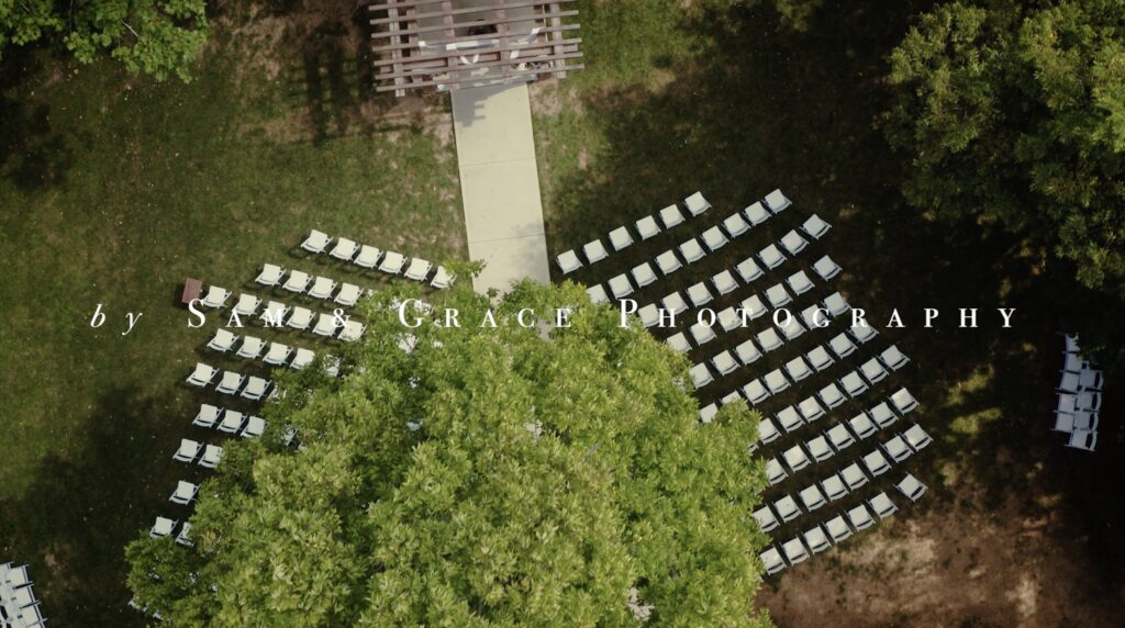 overhead view from a drone of a ceremony spot at upscale barn wedding venue Stone Valley Meadows, with white chairs arranged in front of a wooden arbor