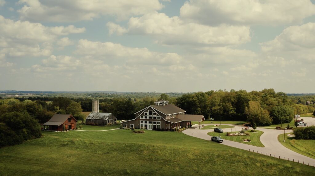 drone bird's eye view of a upscale barn venue Stone Valley Meadows on a sunny day with clouds in the sky