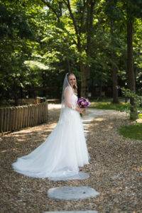 bride poses for photo on a path