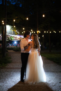bride and groom dancing in the dark under string lights